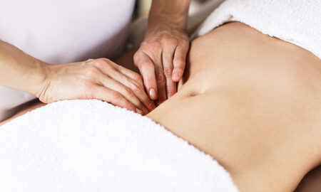 Beautiful young woman having visceral massage in spa center